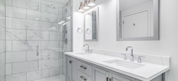 Elegant bathroom with gray marble tiles in the shower area, complemented by a double vanity and modern lighting fixtures.