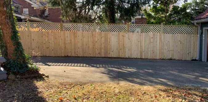 A newly constructed wooden privacy fence with a lattice top, enhancing the security and aesthetics of a residential property, demonstrating expertise in fence construction by a handyman service.