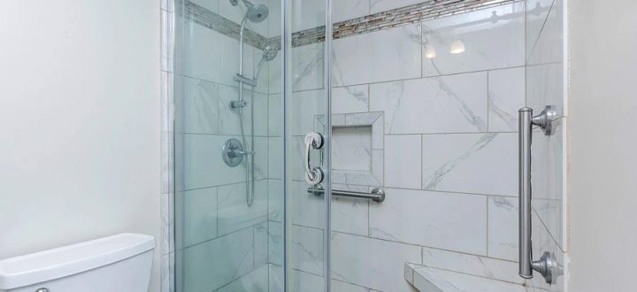 A luxurious bathroom featuring a spacious marble shower with a built-in bench, glass door, and multiple shower heads, offering a sleek and elegant design.